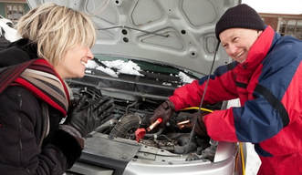 Picture of a man helping a women jump start her car